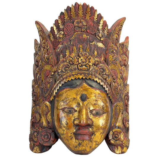 Gedetailleerd vooraanzicht van het handgesneden Balinese dansmasker van Dewi Sinta, tonend de serene gelaatstrekken en de verfijnde, gelaagde kroon.