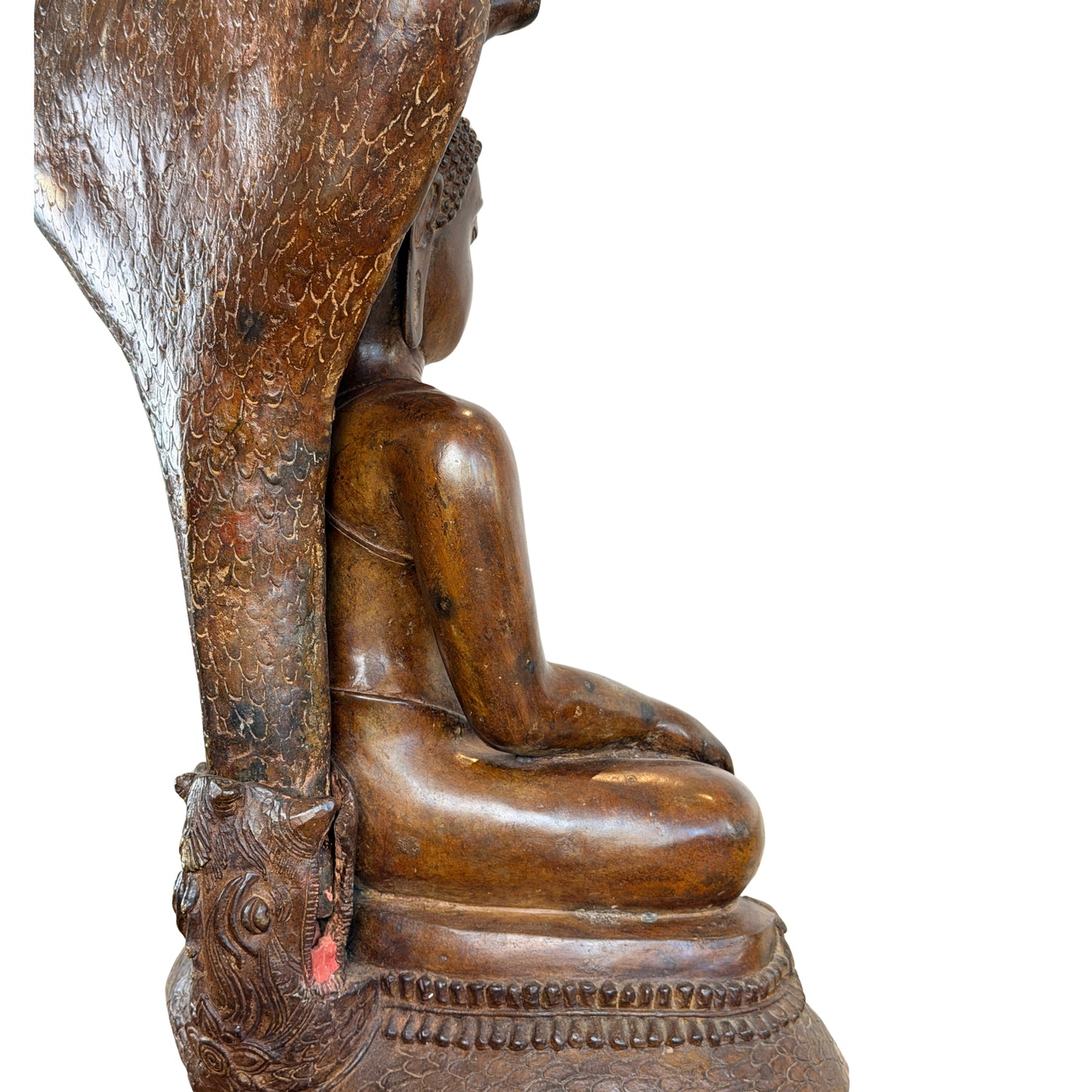 Close-up van het profiel van een groot antiek Thais bronzen Boeddhabeeld, met focus op de aansluiting van de slangenkap achter de rug, het schubbenpatroon en de goudbruine patina