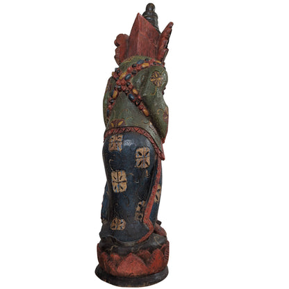 Achterzijde van het handgesneden Indonesische beeld met gedetailleerde kleding.