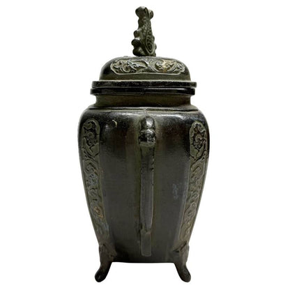 zijaanzicht van de Japanse bronzen brander, met de nadruk op het gegoten handvat en de diepe zwartbruine patina.