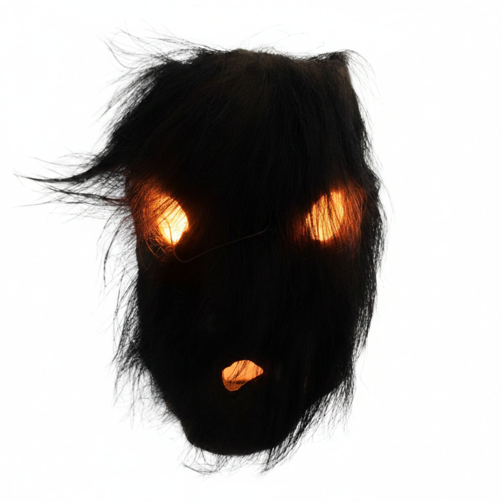 Direct zicht op het rituele masker uit Nepal met de dichte beharing van organisch zwart yak-haar over de oogopeningen en de mondopening.