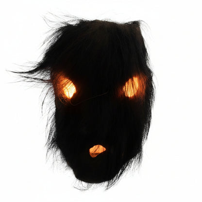 Direct zicht op het rituele masker uit Nepal met de dichte beharing van organisch zwart yak-haar over de oogopeningen en de mondopening.