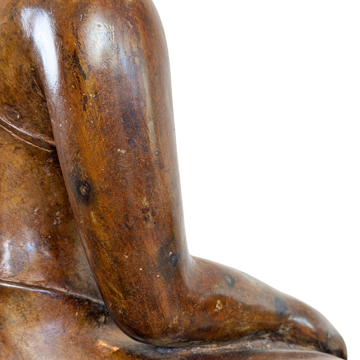 Close-up van de zijkant en de arm van een groot antiek Thais bronzen Boeddhabeeld, met focus op de glanzende oppervlaktehuid, subtiele cuprite-sporen en de zachte textuur van het brons