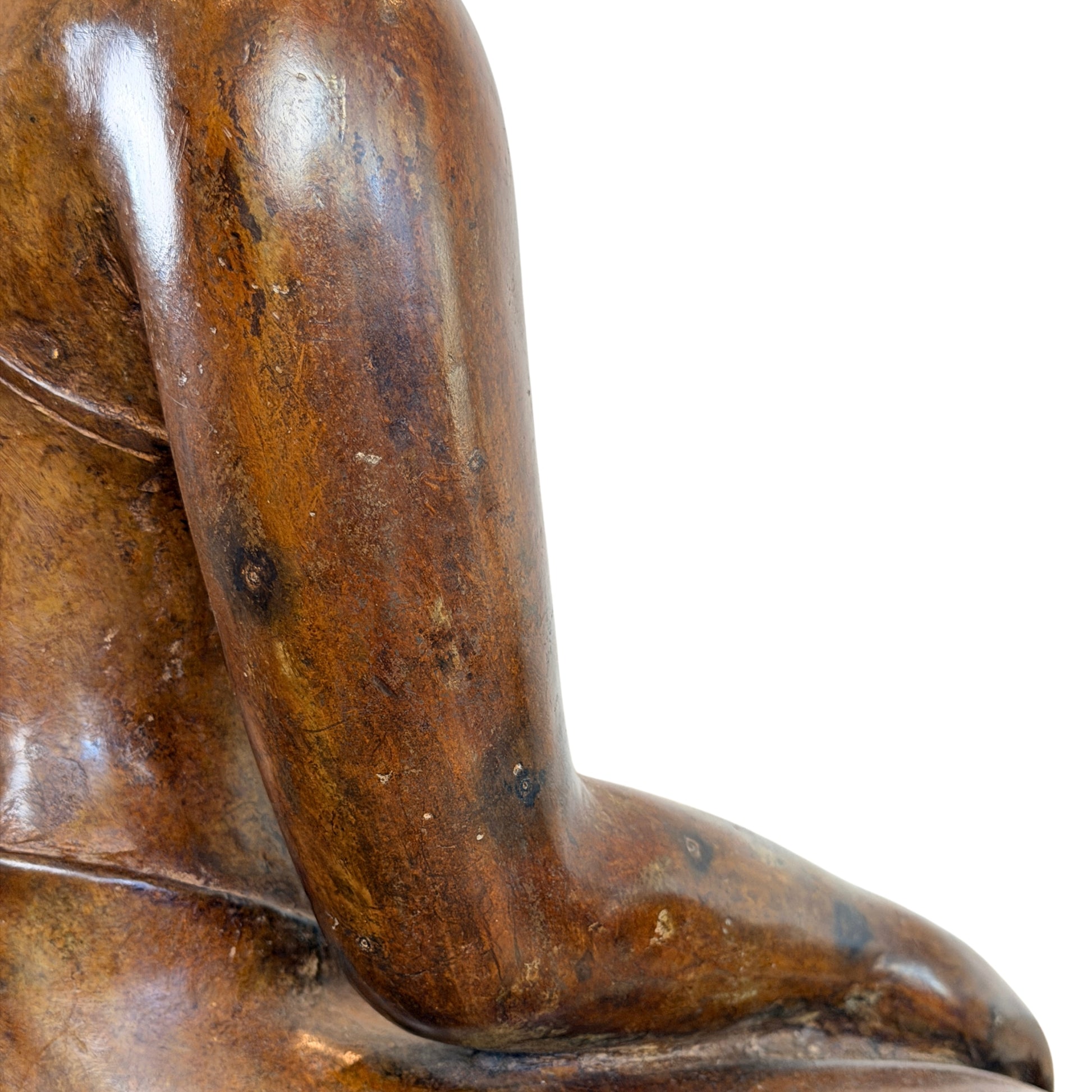 Close-up van de zijkant en de arm van een groot antiek Thais bronzen Boeddhabeeld, met focus op de glanzende oppervlaktehuid, subtiele cuprite-sporen en de zachte textuur van het brons