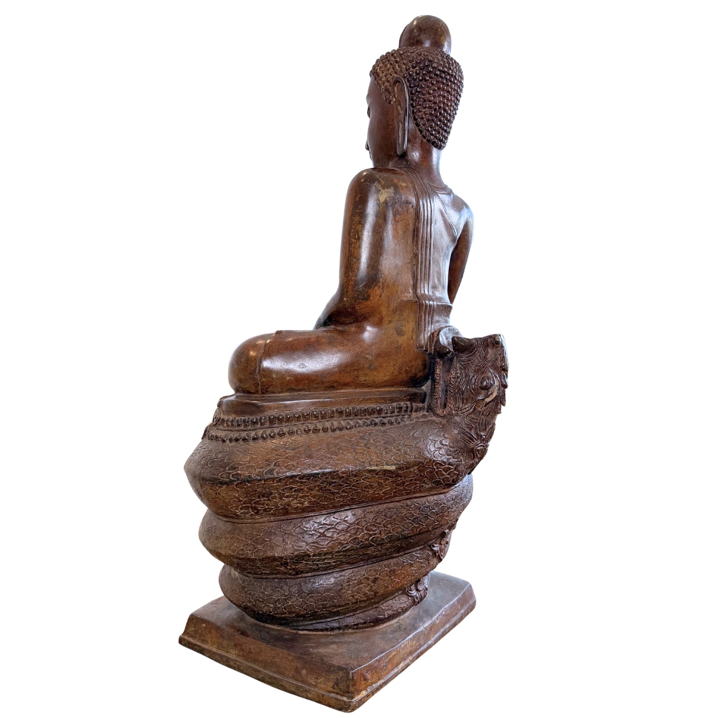 Driekwart achteraanzicht van de rugzijde van een groot antiek Thais bronzen Boeddhabeeld op een bewerkte slangenbasis, tonende de goudbruine patina op de schouders en de contouren van het hoofd