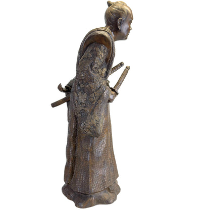 Detailopname van de zwaardgrepen van de Katana en Wakizashi gestoken in de Obi-gordel van het bronzen beeld.