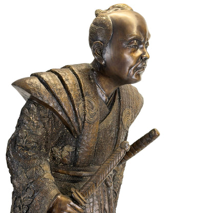 Profielaanzicht van het Japanse bronzen sculptuur tonend de karakteristieke dynamische houding en diepe patina.