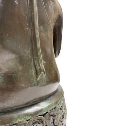 Close-up van de linkerflank van de torso en de overgang naar de troonbasis met natuurlijke goudbruine slijtage op de randen.