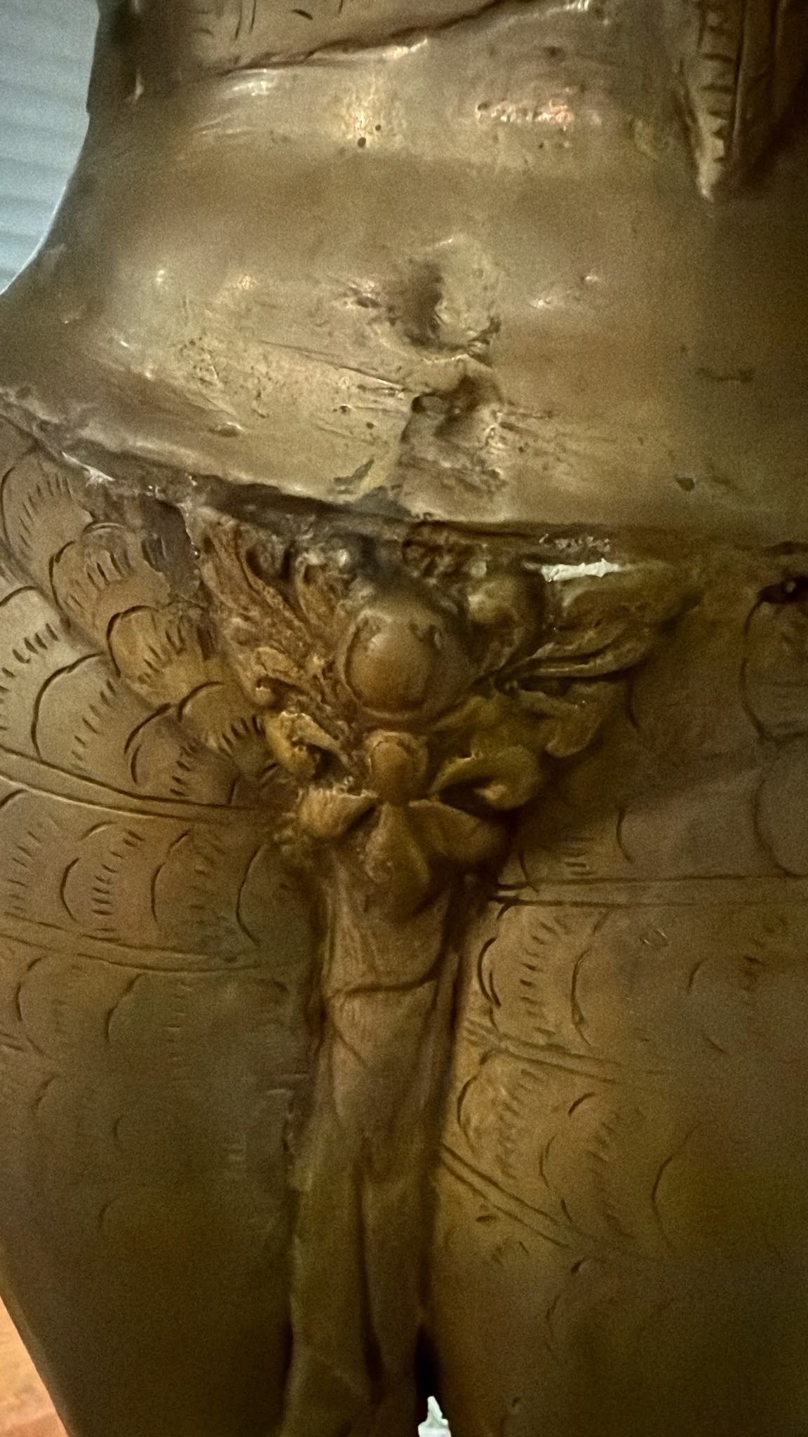Detail van het handgeponste ponsmerk en de handgravures op de hand van een antieke Groene Tara uit Nepal.