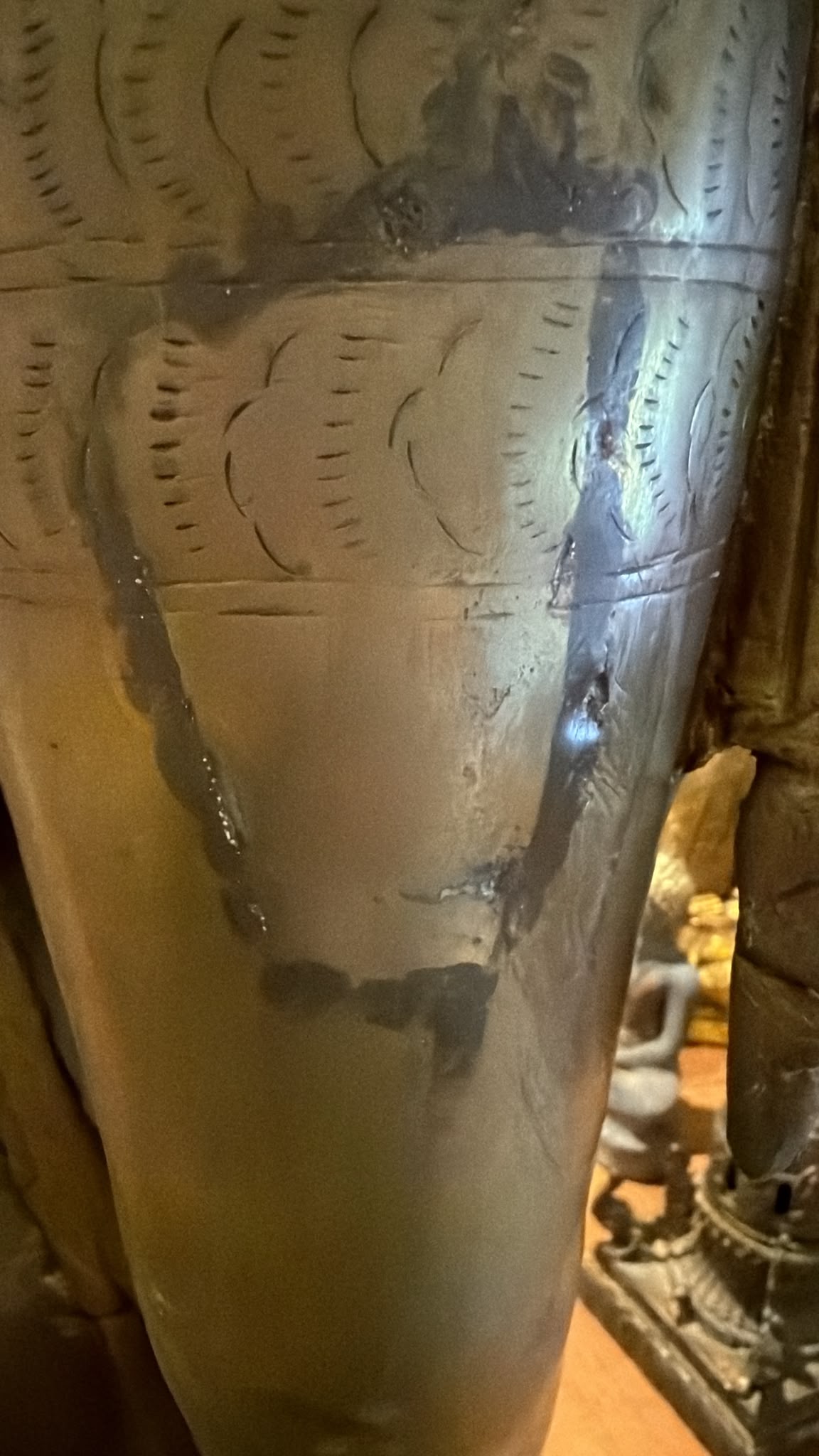 Detail van een historische reparatie aan het been van een antieke Groene Tara uit Nepal, met natuurlijke patina en sporen van langdurige veroudering.