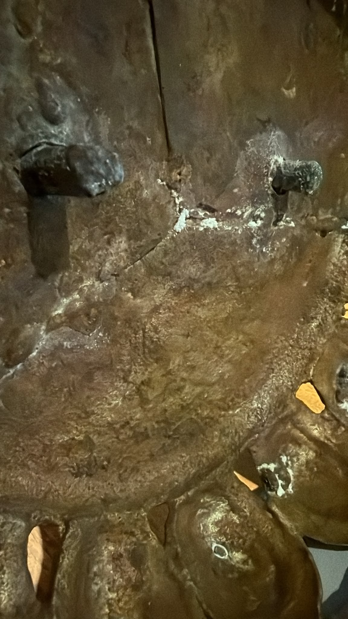 Onderzijde van de lotusbasis van een antieke Groene Tara uit Nepal, met constructiedetails, giettechniek en natuurlijke ouderdomssporen.