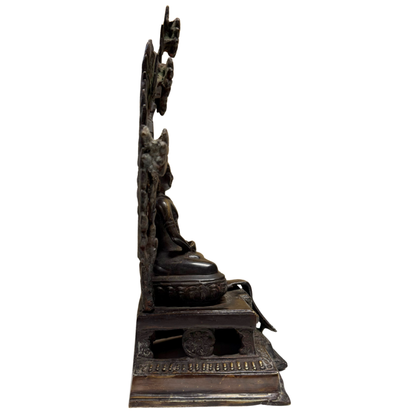 Antieke vuurvergulde boeddha uit de Himalaya traditie met aureool