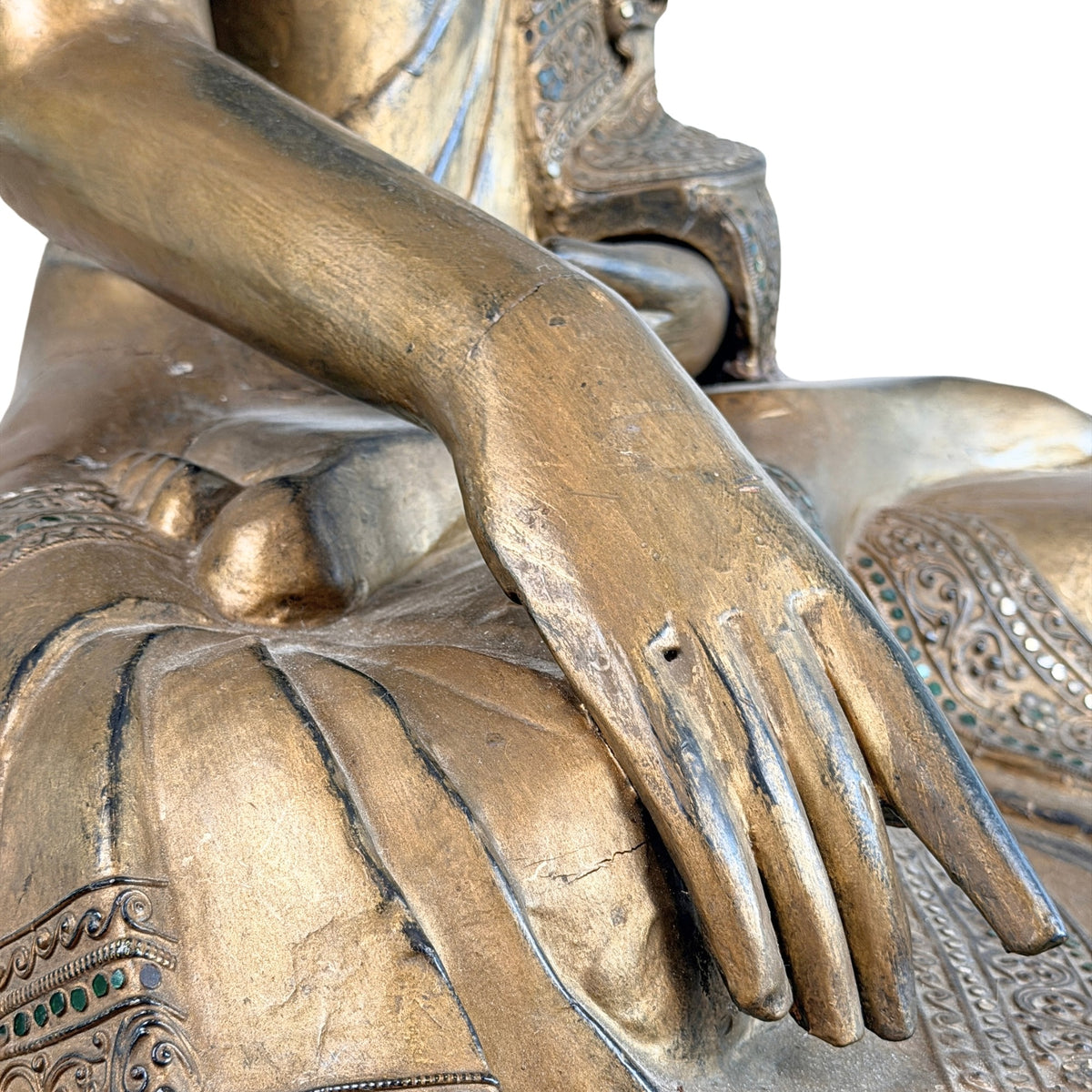 Detail van linkerhand rustend in de schoot van antieke Mandalay Boeddha