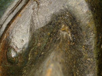 Microscoopdetail van borstoppervlak met donkere en groenblauwe patina op de antieke bronzen Boeddha