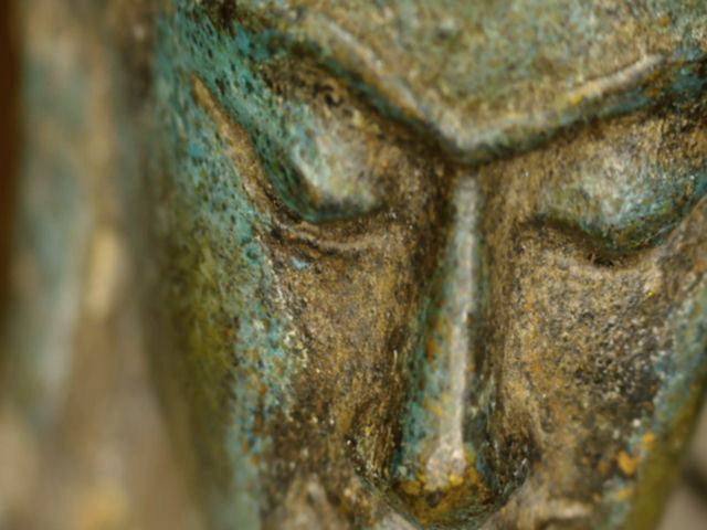 Microscoopdetail van ogen, neus en oude patina op het gezicht van de antieke Thaise Boeddha