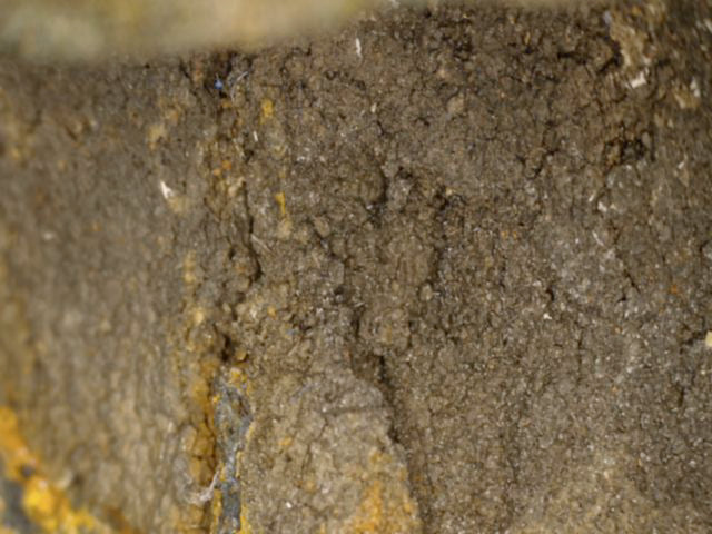 Microscoopdetail van gemineraliseerde oorspronkelijke gietkern met oude scheuren