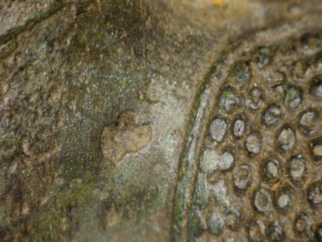 Microscoopdetail van haargrens en patina op antieke Thaise bronzen Boeddha met sporen van oude vergulding