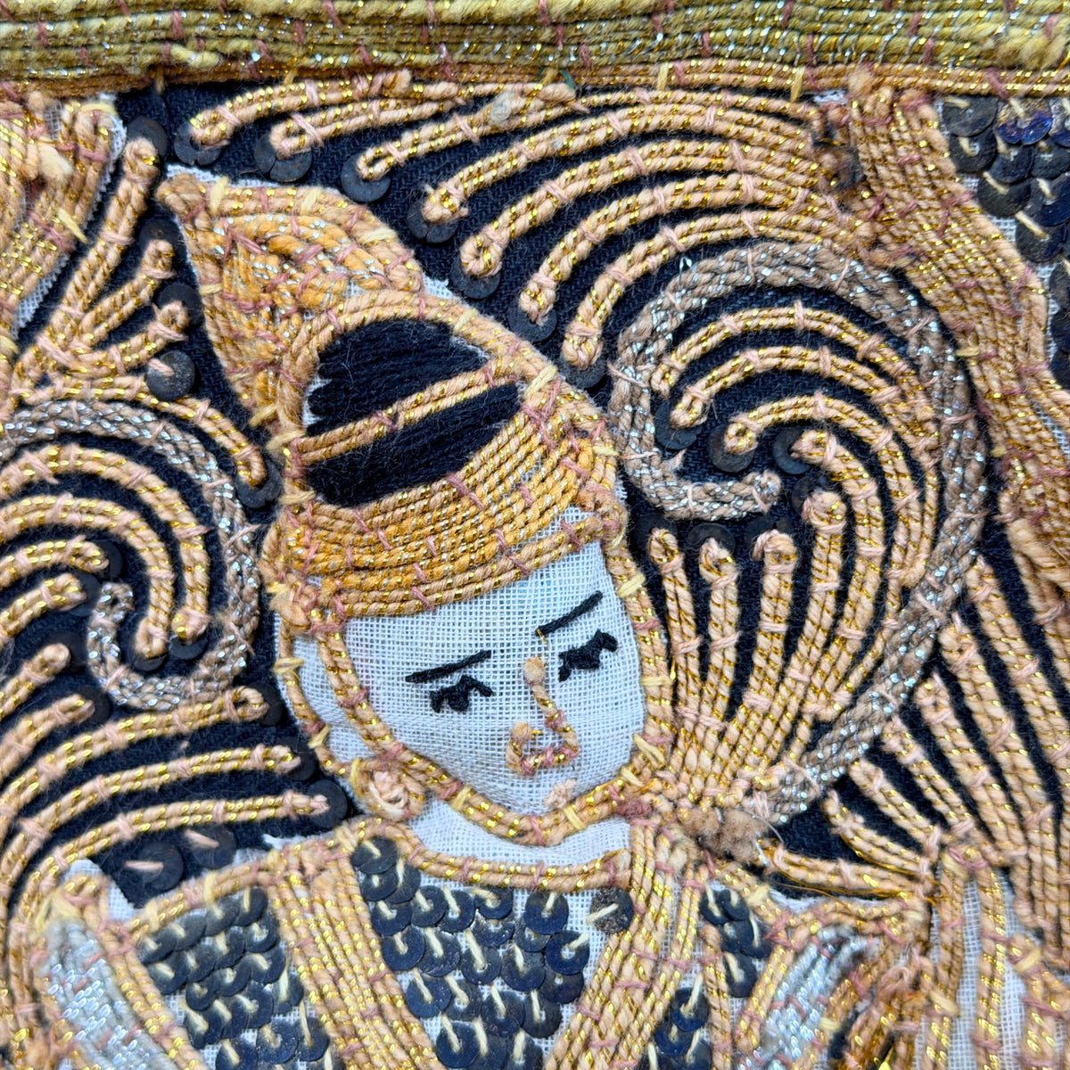Gezicht met kroon in pailletten en gouddraad, detail