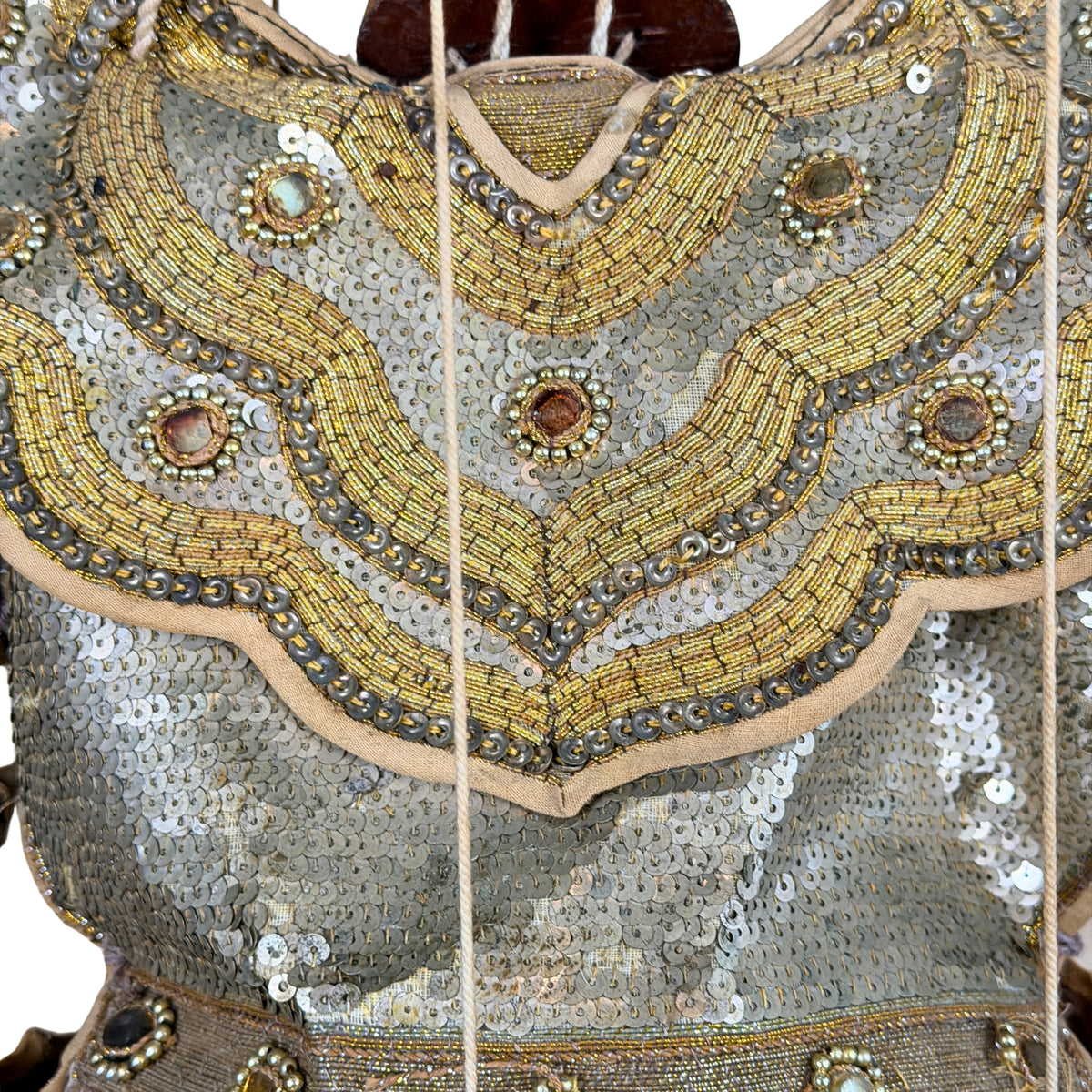 Goudkleurig borduurwerk en pailletten op de borst, detail