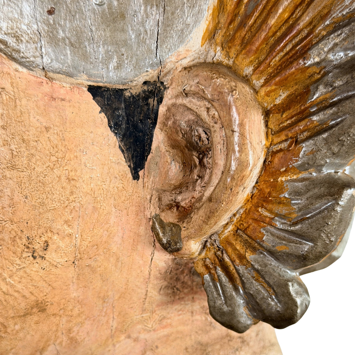 Birmese Nat-figuur: close-up van het oor en de vleugelvormige versiering