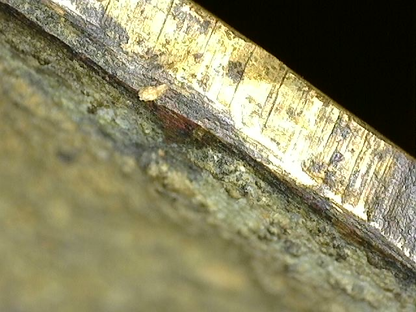 Microscopische gelaagde patinastructuur op antiek vuurverguld Brahma-beeld