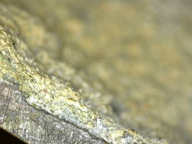 Microscopisch zicht op cuprit en donkere oxidatie op antiek Brahma-beeld