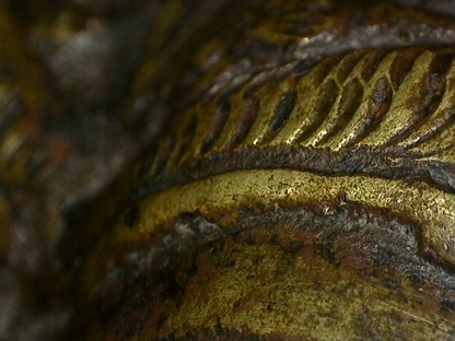 Microscoopdetail van rituele contactslijtage op bronzen Brahma-beeld