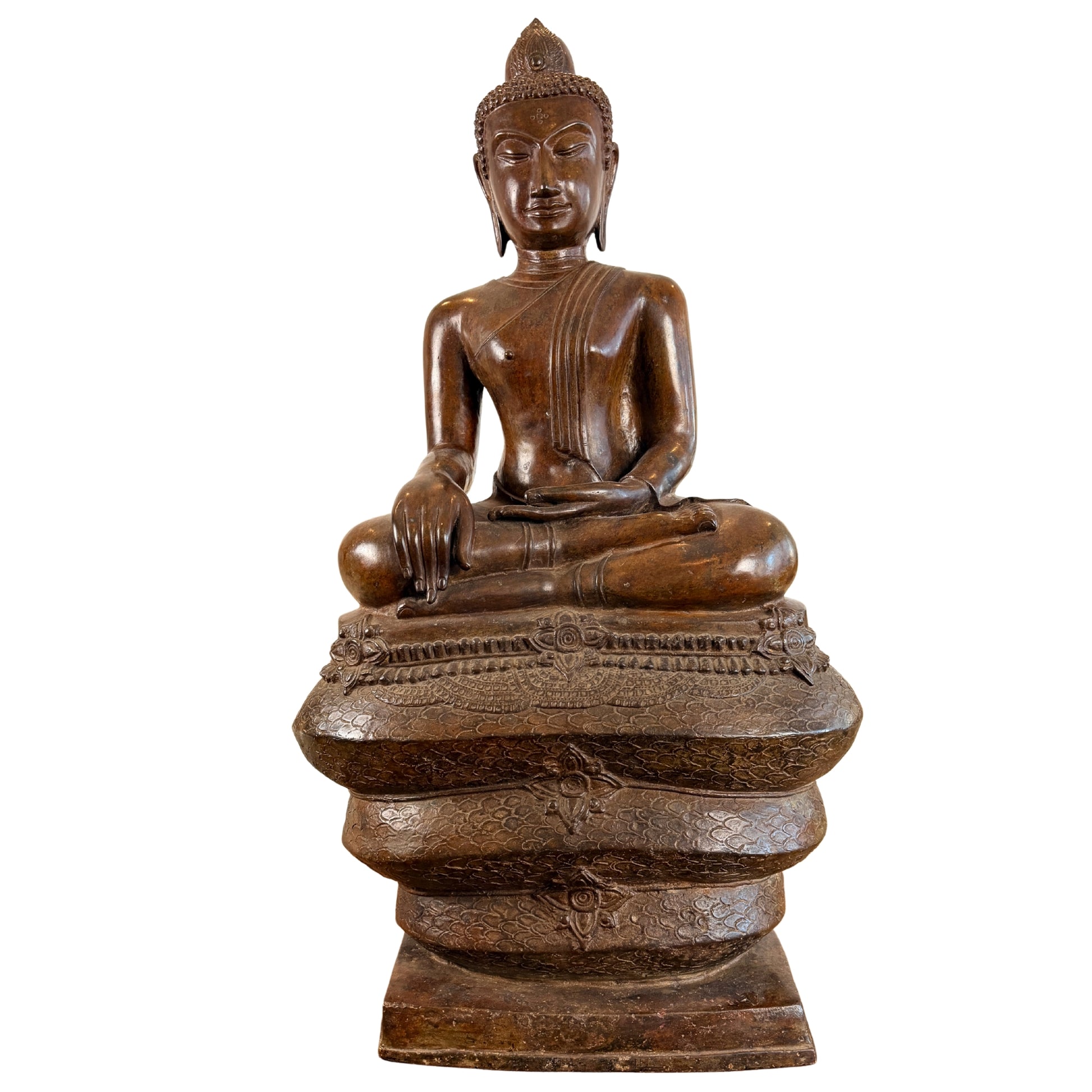 Volledig vooraanzicht van een monumentaal bronzen Boeddhabeeld van 122 cm hoog in bhumisparsha mudra, gezeten in de halve lotusbouding op de drie opgerolde en gedecoreerde windingen van de Naga-slang, gefotografeerd zonder het afneembare slangenscherm.