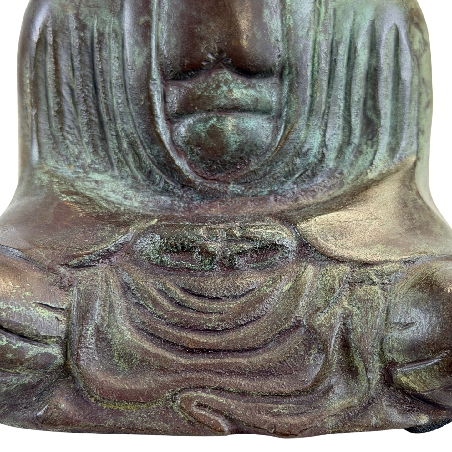 Handen boven elkaar in de schoot in Dhyana Mudra, met geplooid gewaad