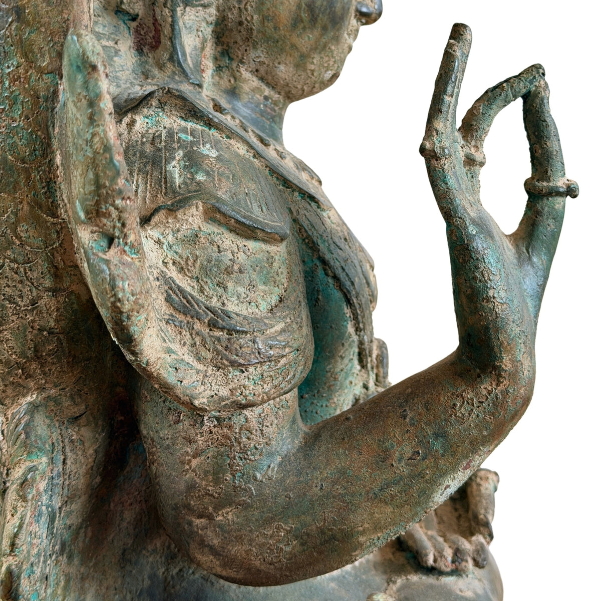 Detail in profiel van de opgeheven hand, arm en schouder van de bronzen Boeddha