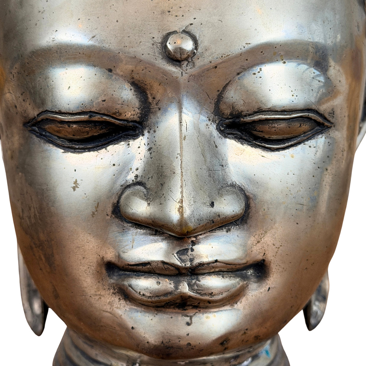 Gezicht van de bronzen Boeddhakop met grote ronde urna en neergeslagen ogen