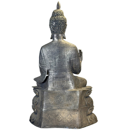 Volledig achteraanzicht van de Chinese Boeddha met gedecoreerd ruggewaad en geometrische patronen op de sokkel.