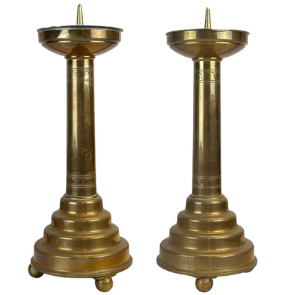 Set decoratieve messing kandelaars in klassieke altaarstijl met getrapte voet en bolpootjes.