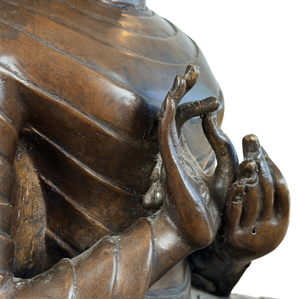 Geribde gewaadplooien op de arm en hand in dharmachakra mudra, detail