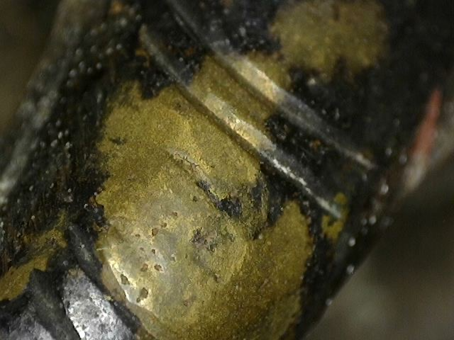 Microscoopbeeld van vuurverguldingsresten op antiek bronzen Ganesha-beeld