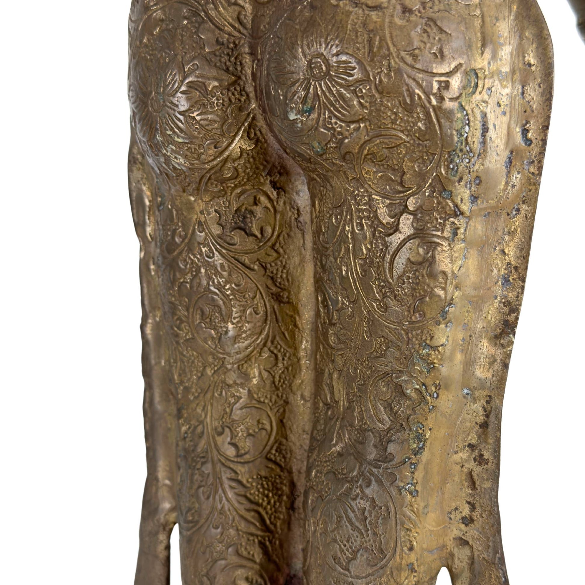 Close-up van de rijk gegraveerde dhoti met florale motieven, natuurlijke patina en resten van vuurvergulding.