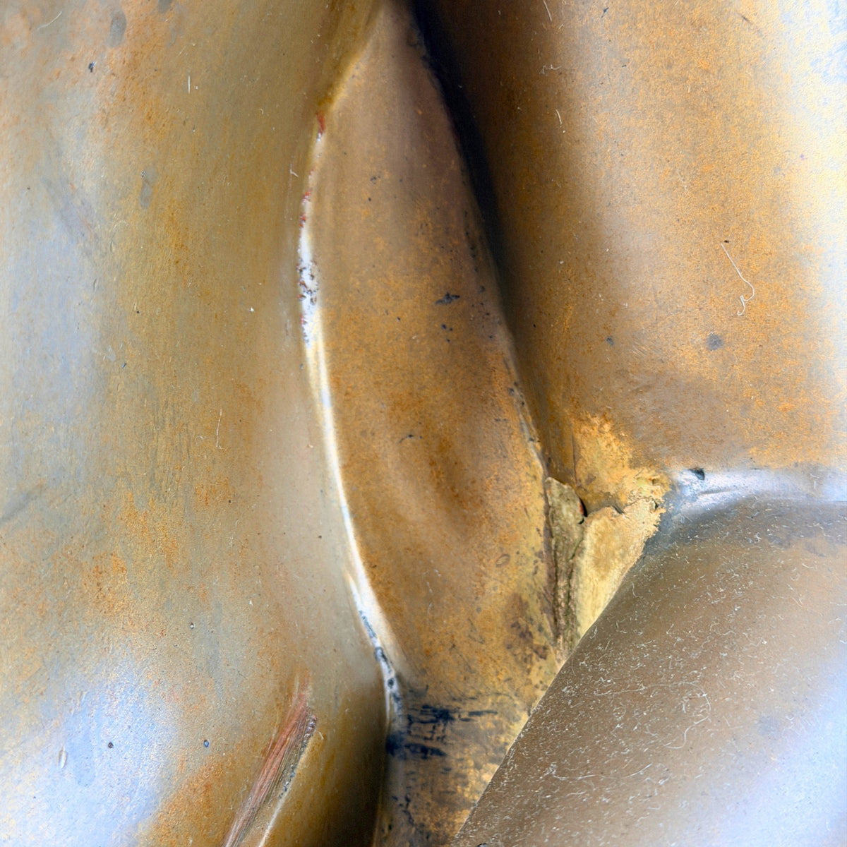 Aansluiting van arm en lichaam met oude vulling en goudbruine patina, detail