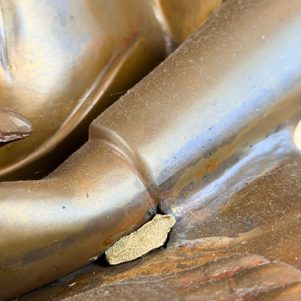 Onderarm bij de schoot met oude vulling en resten van rode lak, detail