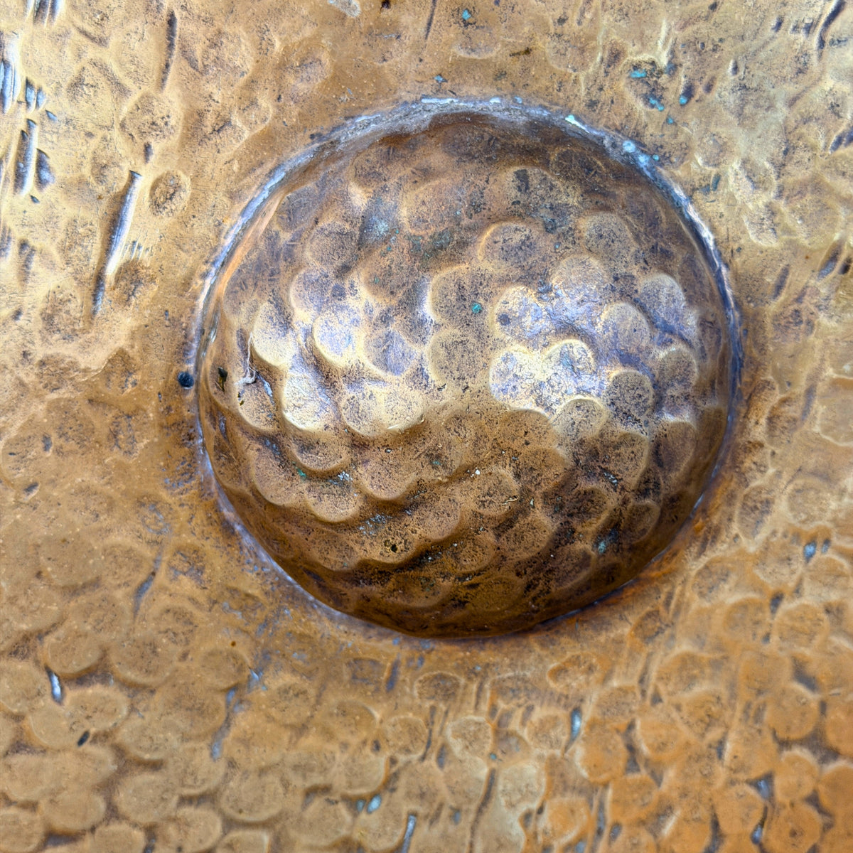 Verhoogde gehamerde middenknop van de messing gong, detail