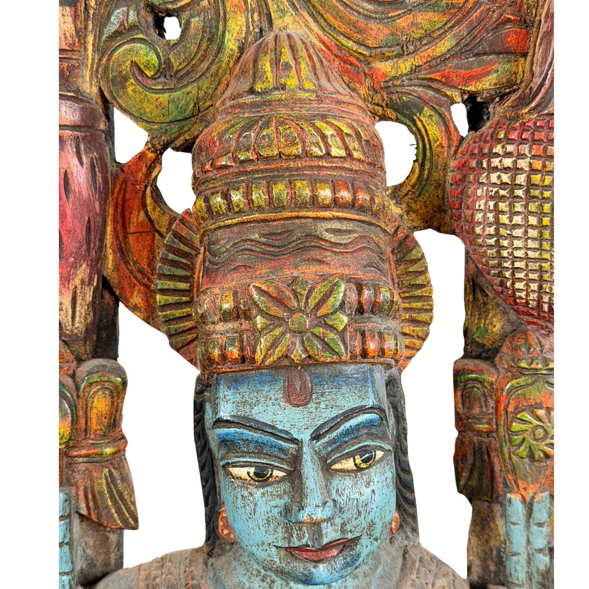 Blauw gezicht van Krishna met rode voorhoofdsmarkering onder de hoge bewerkte kroon