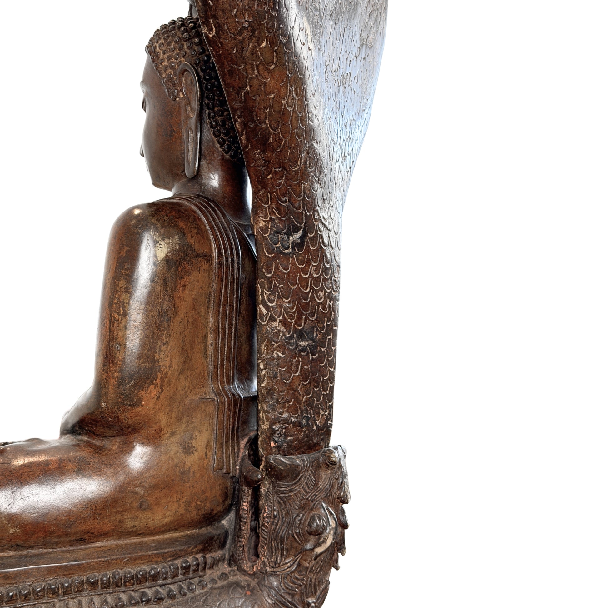 Gedetailleerde macro-opname van de achterzijde van een bronzen Boeddhabeeld, tonende de aansluiting van het naga-scherm met geciseleerde schubben op de troonbasis en de parallelle plooien van het gewaad op de rug