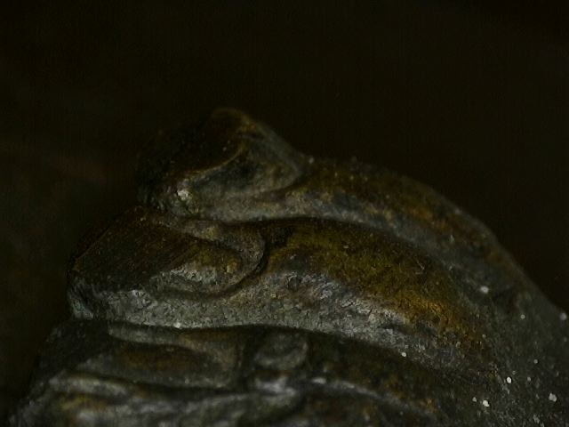 Microscoopdetail van diepe patina-opbouw op antiek Thais bronzen kunstwerk