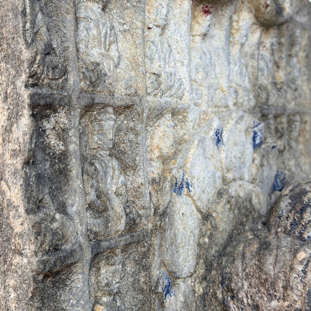 Detail van knielende dragende figuren in de stele