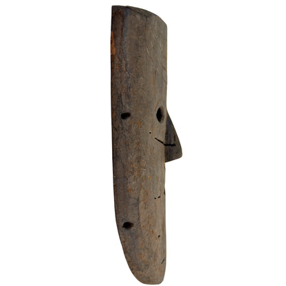Linker profiel van Nepalees houten masker met vooruitstekende neus en randgaten