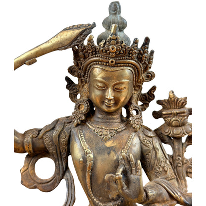 Manjushri van voren met versierde borst, geheven rechterarm en lotus naast de schouder