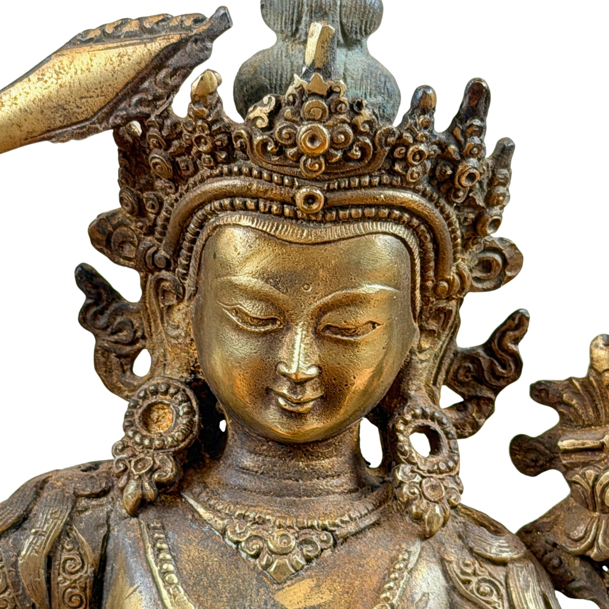 Gezicht van Manjushri met halfgesloten ogen, sierkroon en ronde oorhangers