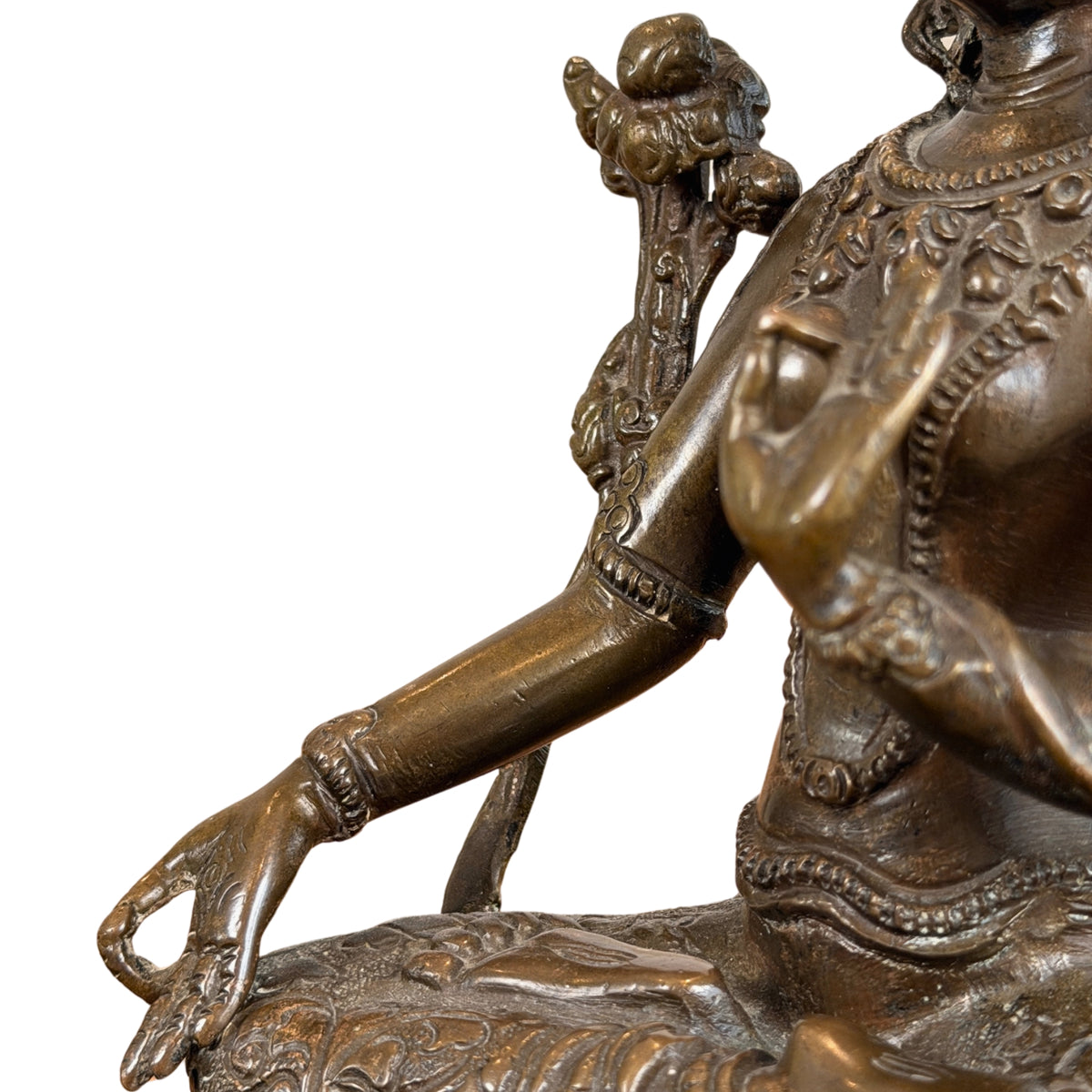 Rechterhand in varada mudra op de knie, met armbanden en lotusstengel, detail