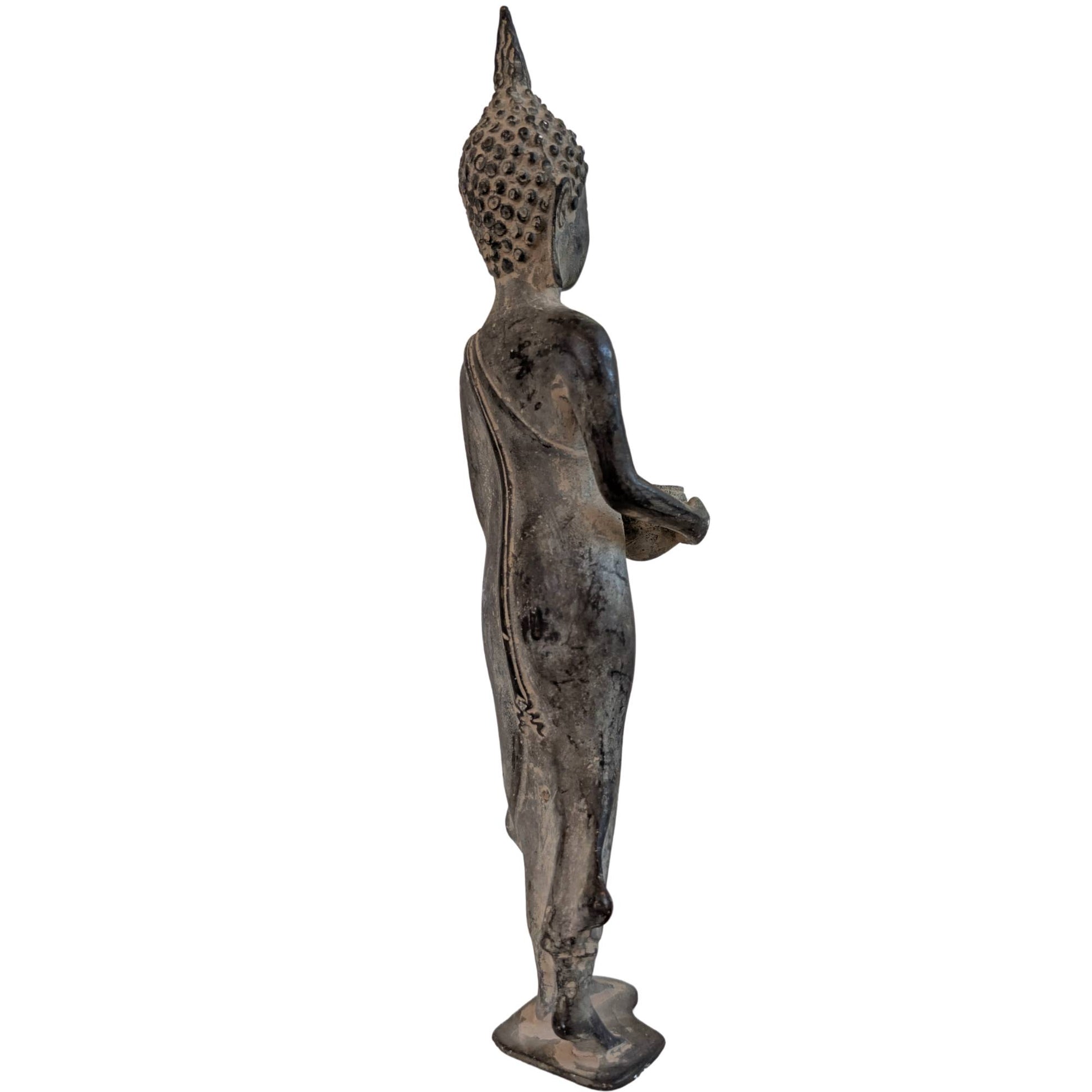 Staande bronzen Shakyamuni Boeddha uit Thailand met almoezenschaal op een witte achtergrond.