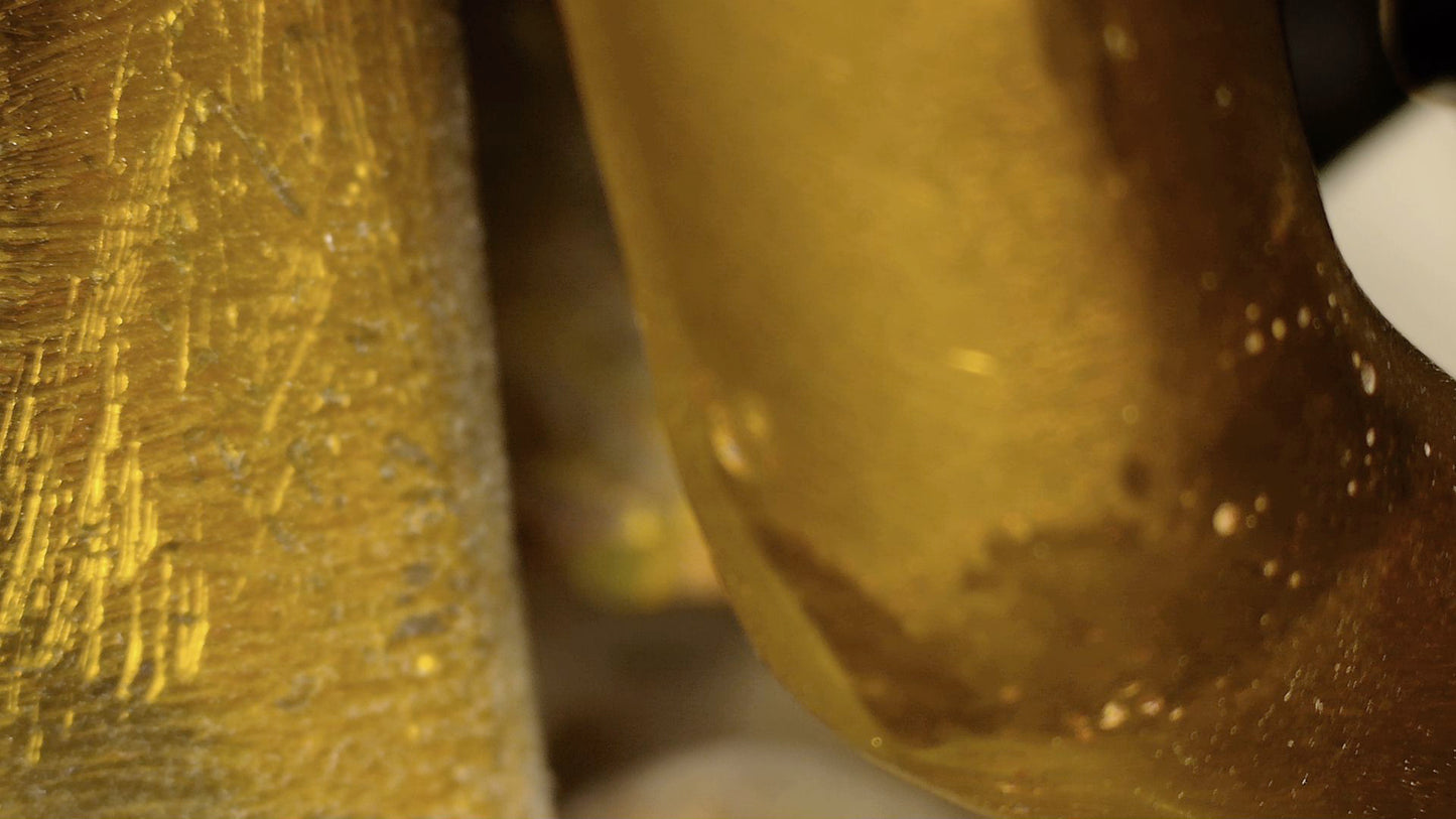 Microscoopdetail van oude krassen en bruine patina op antieke Tibetaanse Boeddha