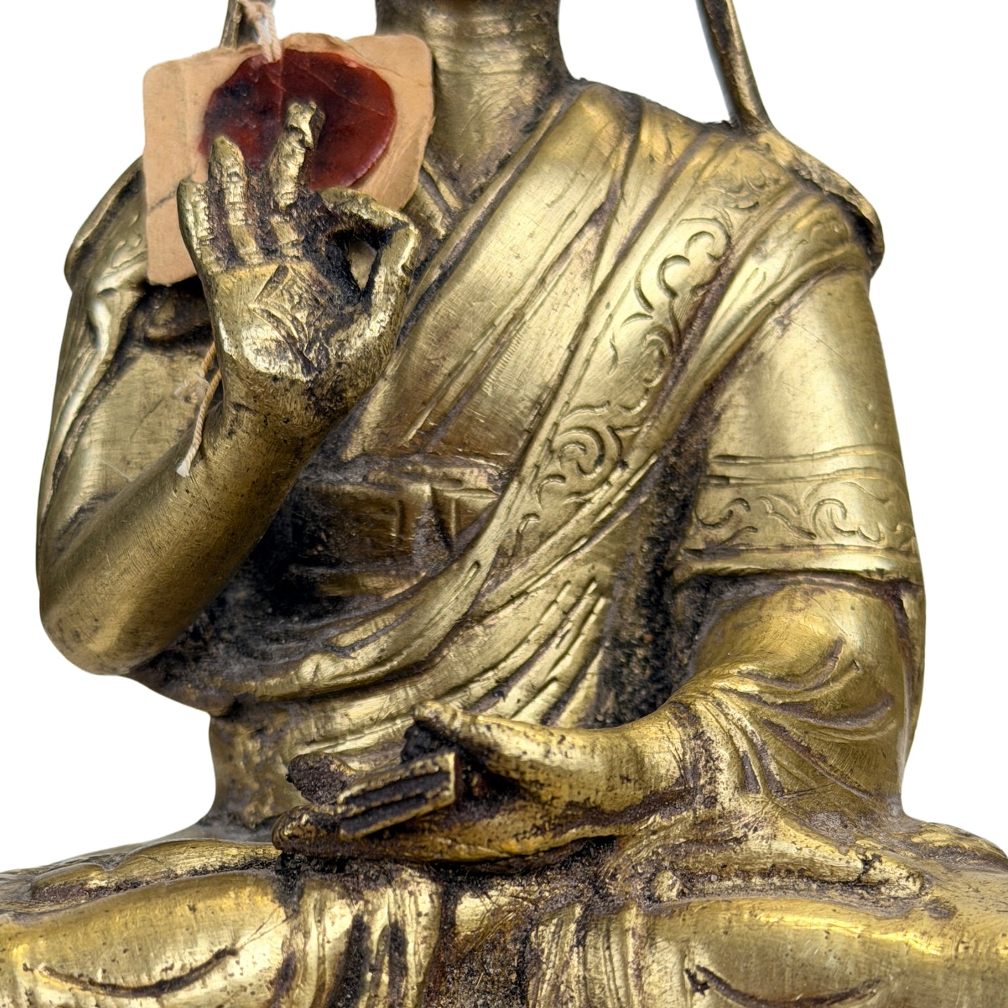 Detail van onderrichtsgebaar en gebonden religieus manuscript bij een Tibetaanse Gelug lama